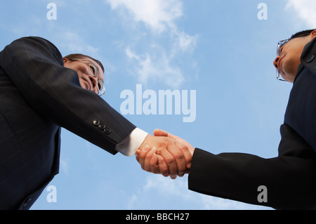 Two businessmen shaking hands, low angle view Stock Photo