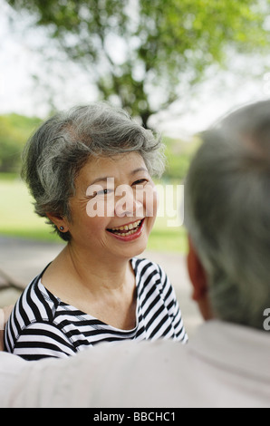 Mature couple facing, woman wearing striped shirt, smiling Stock Photo