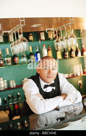 Bartender behind bar counter, arms crossed Stock Photo