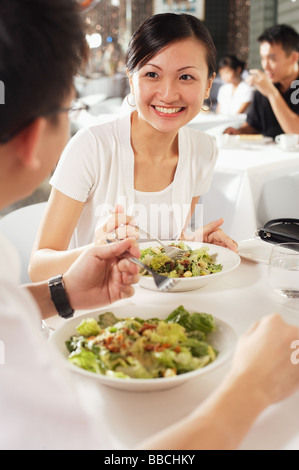 Couple eating at restaurant, over the shoulder view Stock Photo