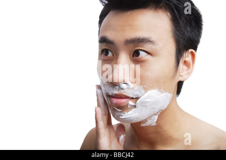Man applying shaving cream to face Stock Photo