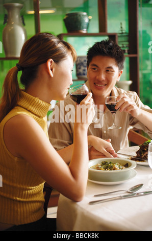 Couple dining in Chinese restaurant, drinking wine Stock Photo