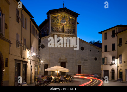 Night view of street cafe and facade of Basilica Di San Frediano, Lucca, Tuscany, Italy Stock Photo