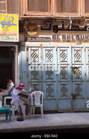 Man in traditional dress outside cafe Jeddah Saudi Arabia Stock Photo