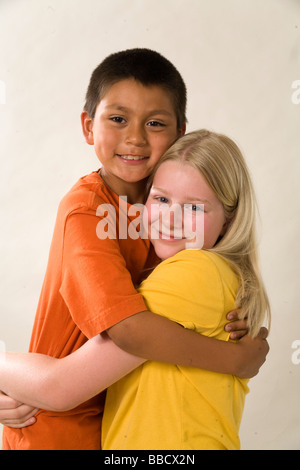 multi ethnic racial diversity racially diverse multicultural cultural Portrait young girl 11-12 adopted Hispanic 8-9 year old younger brother having fun Stock Photo