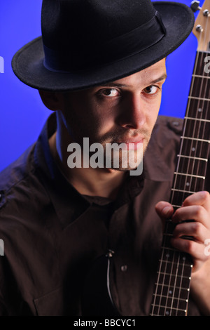 Guitar player against blue backgroung Stock Photo