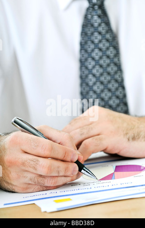 Office worker reviewing generic presentation charts and reports Stock Photo