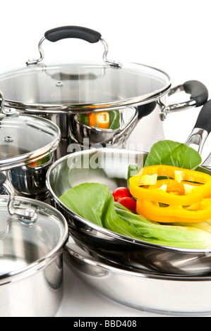 Stainless steel pots and pans isolated on white background with vegetables Stock Photo