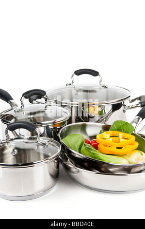 Stainless steel pots and pans isolated on white background with vegetables Stock Photo