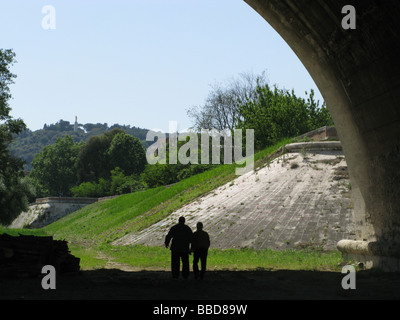 two men walking under bridge in rome italy Stock Photo