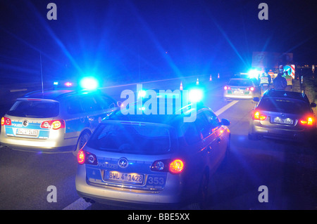 Police patrol car with flashing lights securing an accident scene on the highway A 8 en route to Munich between the airport and Stock Photo