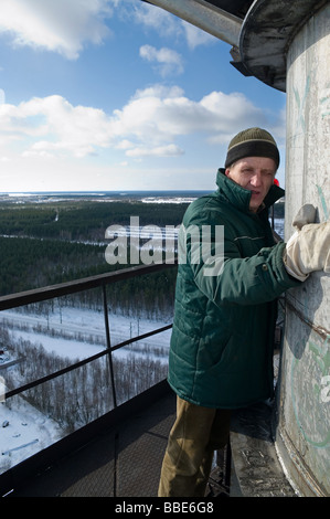 Man stays on the mounting pad of chimney. He is afraid of it. Bird eye view on the land Stock Photo