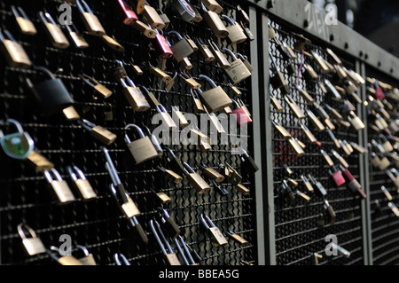 Padlocks as a symbol of friendship and love on the fence of the Hohenzollern Bridge in Cologne, North Rhine-Westphalia, Germany Stock Photo