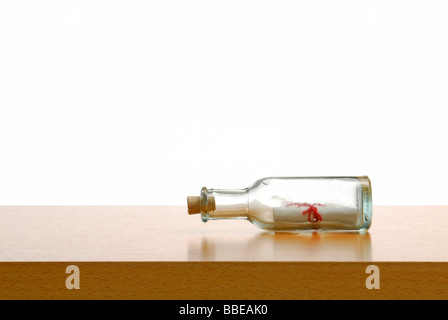 Message in a bottle on a desk, symbolic image for communication Stock Photo