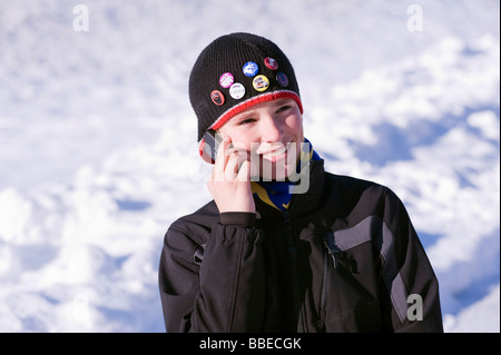 Boy Talking on Cell Phone Outdoors in Winter, Salzburger Land, Austria Stock Photo
