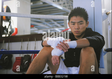 Japanese boxer sitting in Boxing ring Stock Photo