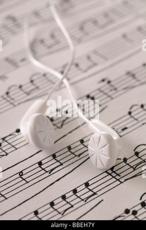 Ear Buds Resting on Sheet Music Stock Photo