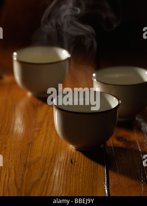 Three Cups of Steaming Hot Tea on Wooden Table