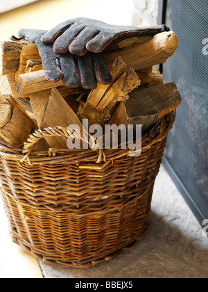 Leather Gloves on Basket of Logs Stock Photo