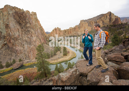 Hikers Standing on a Cliff Above Crooked River in Smith Rock State Park in Autumn, Bend, Oregon, USA Stock Photo