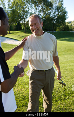 Friends Shaking Hands on Golf Course, Burlington, Ontario, Canada Stock Photo