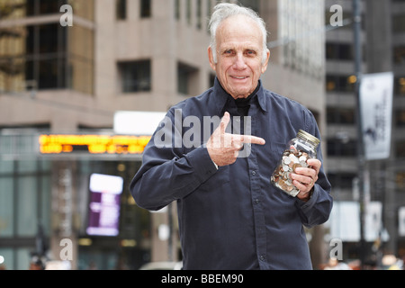 Portrait of Man Holding Jar of Coins Stock Photo