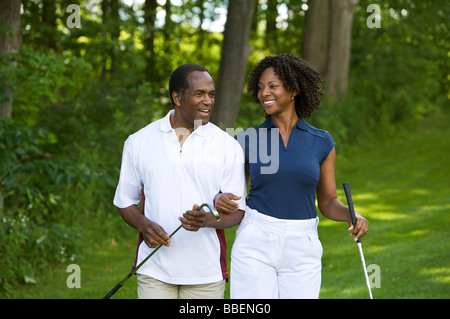 Couple Walking on Golf Course Stock Photo