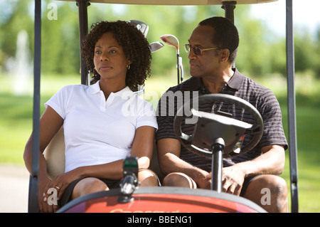 Couple Sitting in Golf Cart Stock Photo