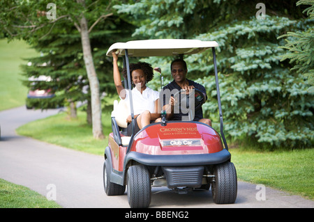 Couple Riding in Golf Cart Stock Photo