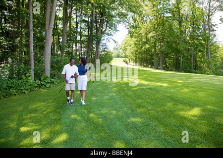 Couple Walking on Golf Course Stock Photo