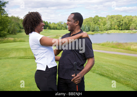 Couple Embracing on Golf Course Stock Photo