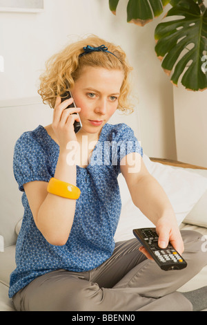 Woman using TV Remote Stock Photo