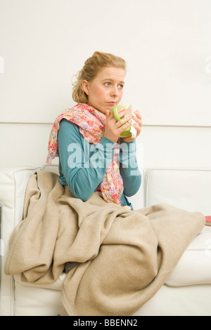 Woman holding Mug Sitting on Sofa Stock Photo