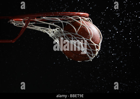 Basketball going through hoop Stock Photo