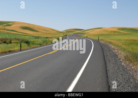 Blacktop country road winding off into the distance Stock Photo