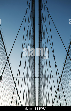 Iron support wires of suspension bridge against blue sky, low angle view