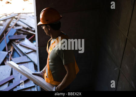 Construction worker carrying scrap wood cleaning up construction site Stock Photo