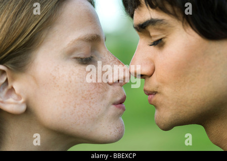 Young couple touching noses, puckering, profile Stock Photo
