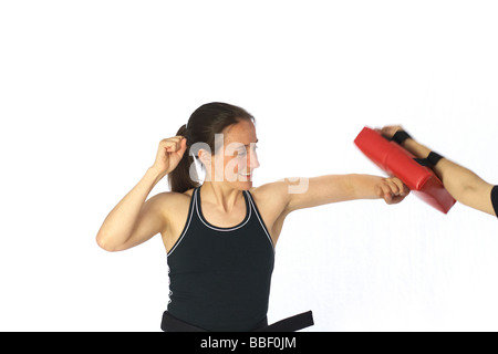 A woman wearing martial arts clothing exercising Stock Photo