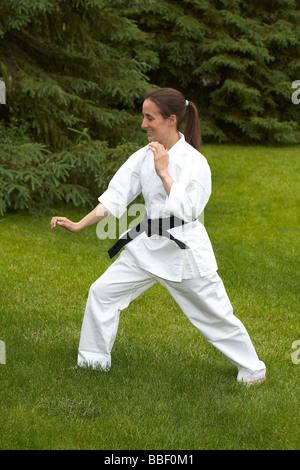 A woman wearing martial arts clothing exercising Stock Photo