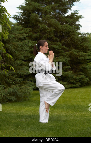 A woman wearing martial arts clothing exercising Stock Photo