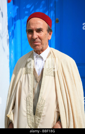 Smiling elderly man wearing a djellaba and a red fez Stock Photo