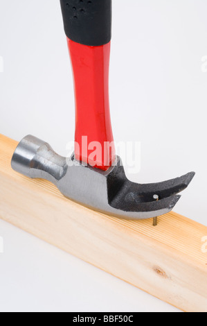 Using a claw hammer to remove a nail from timber Stock Photo