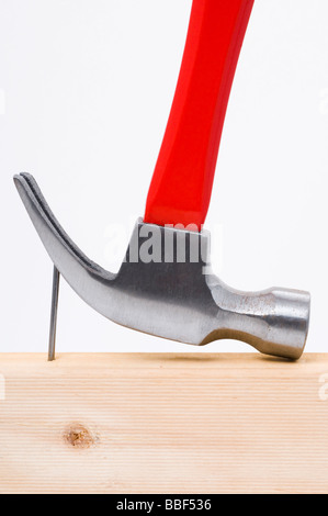 Using a claw hammer to remove a nail from timber Stock Photo