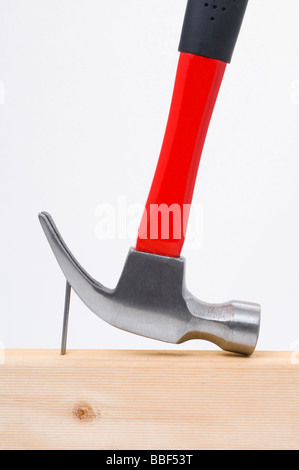 Using a claw hammer to remove a nail from timber Stock Photo
