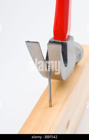 Using a claw hammer to remove a nail from timber Stock Photo