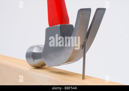 Using a claw hammer to remove a nail from timber Stock Photo