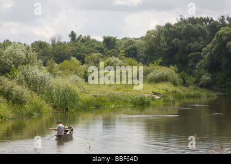 Russian villager enjoys fishing from a small boat on Khoper river in Penza region south of Urals mountains in Central part of European Russia. Stock Photo