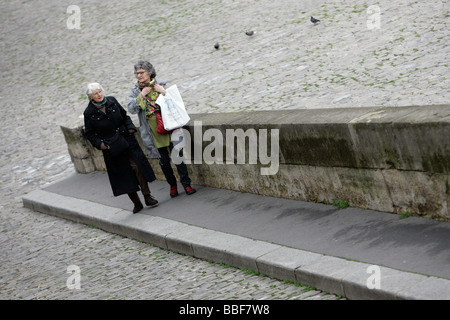 Two woman stroll on the quai along the Seine, Paris Stock Photo
