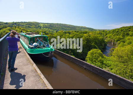 Young girl taking photograph of canal boat crossing River Dee near Llangollen on the Shropshire Union canal Pontcysyllte aqueduc Stock Photo